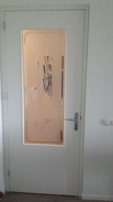 Eenvoudige witte deur met groot raam